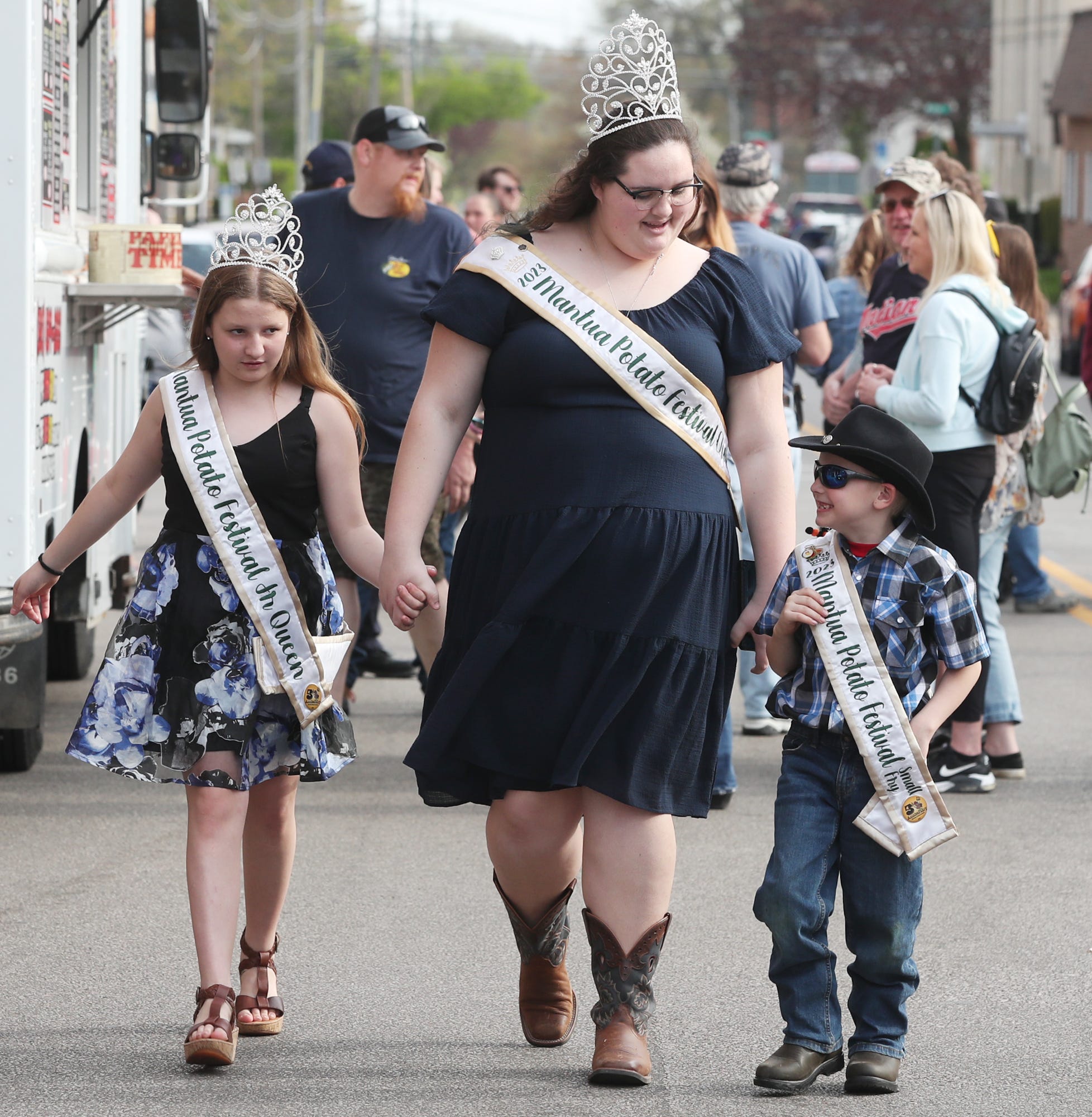 Mackenzie Thompson 2023 Mantua Potato Festival Queen, center, walks with Hailey Roosa the 2023 Junior Queen, left and Hudson Roosa-Varner, 2023 Small Fry as they take in the Ravenna JoJo Fest on Friday, April 26, 2024 in Ravenna.
