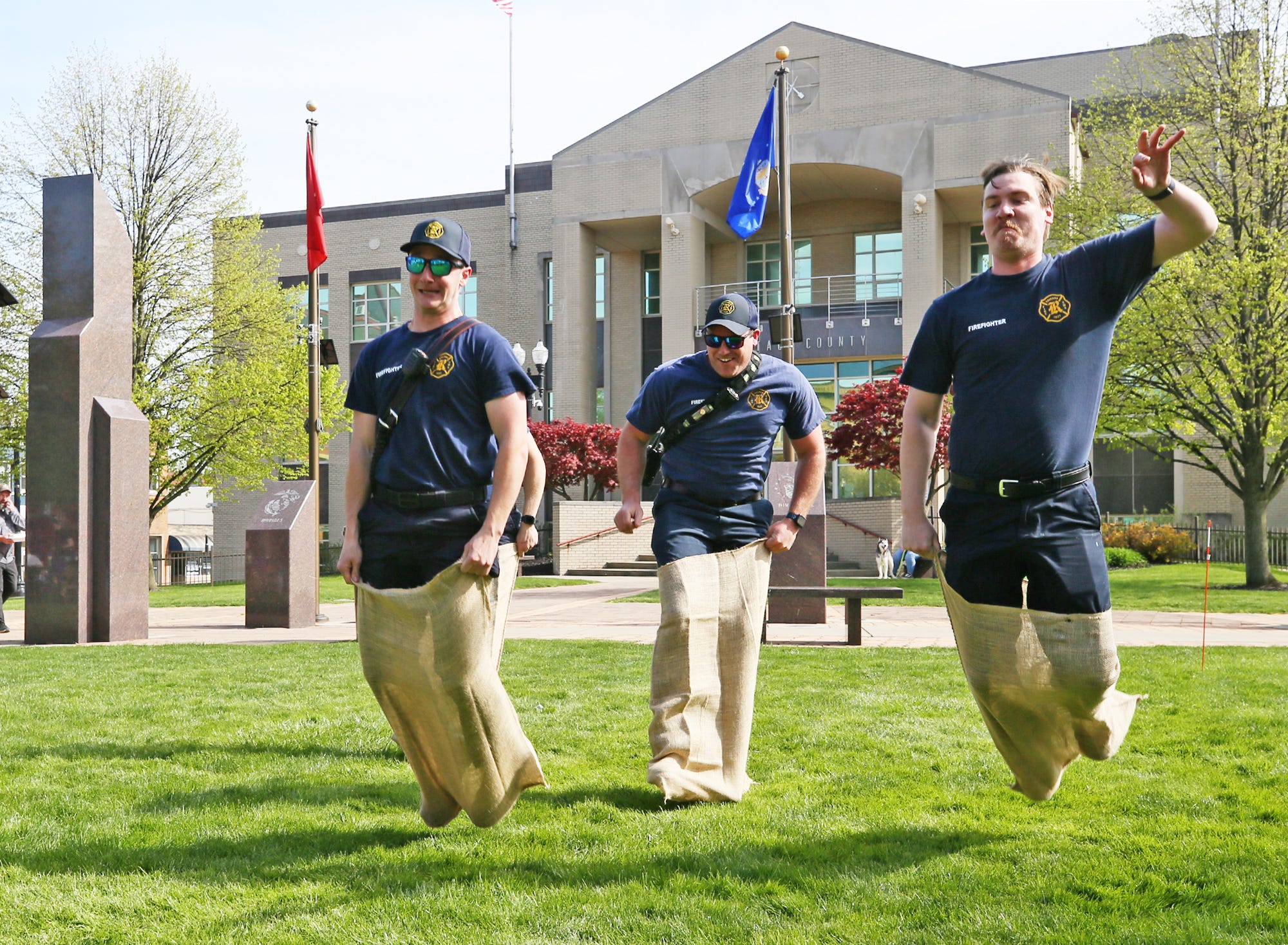 Ravenna Fire/Medics, from left, Grant Semaca, Jesse Zivoder and Sean Bryant, are the first to compete in the potato sack race during the Ravenna JoJo Fest on Friday, April 26, 2024 in Ravenna.